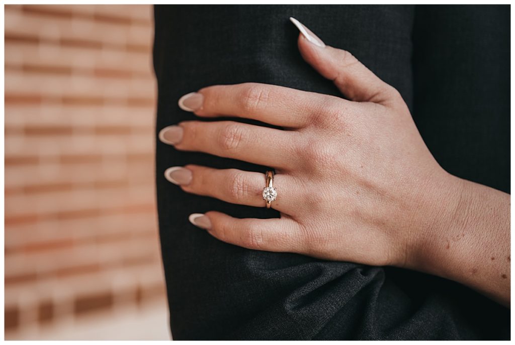 A gold ring with a circle diamond on a bride's finger by Houston Wedding Photographer, Brittany Emmanuel.