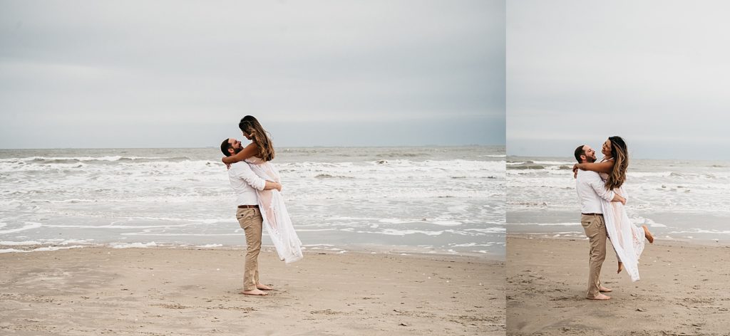 Man lifting up woman and twirling her around on the sand for their beach engagement session in Galveston. 