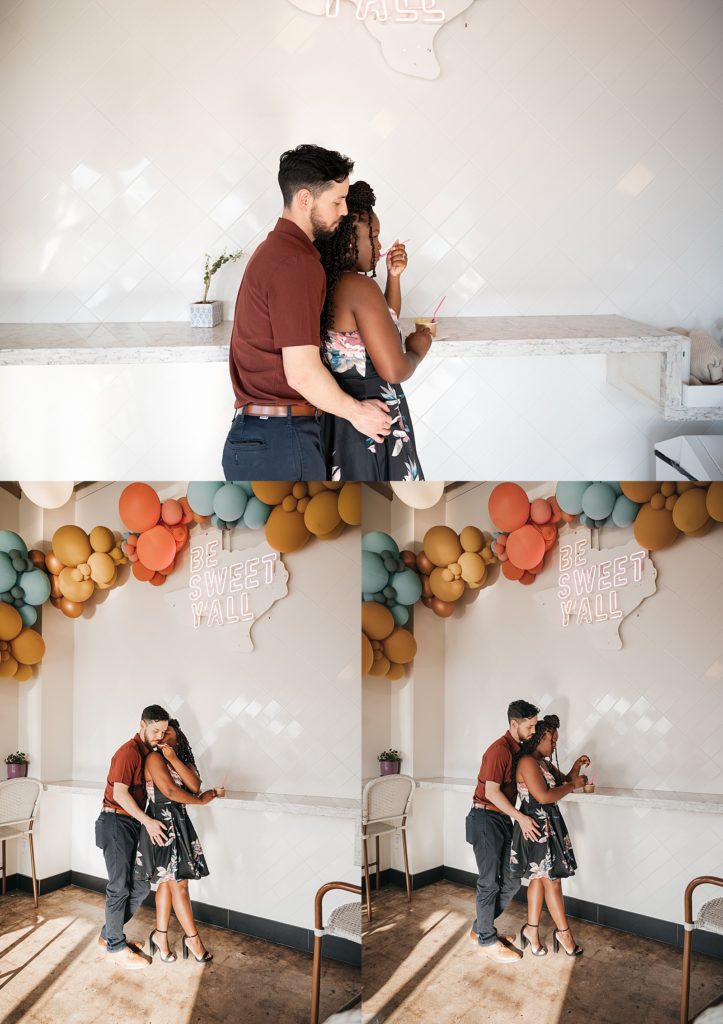 Couple sharing ice cream under orange, coral and blue balloons at shoot with Houston engagement photographer. 