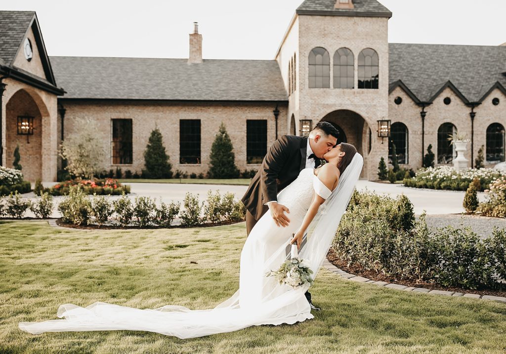 Groom dipping bride with veil in a garden for this elegant & neutral Houston wedding. 