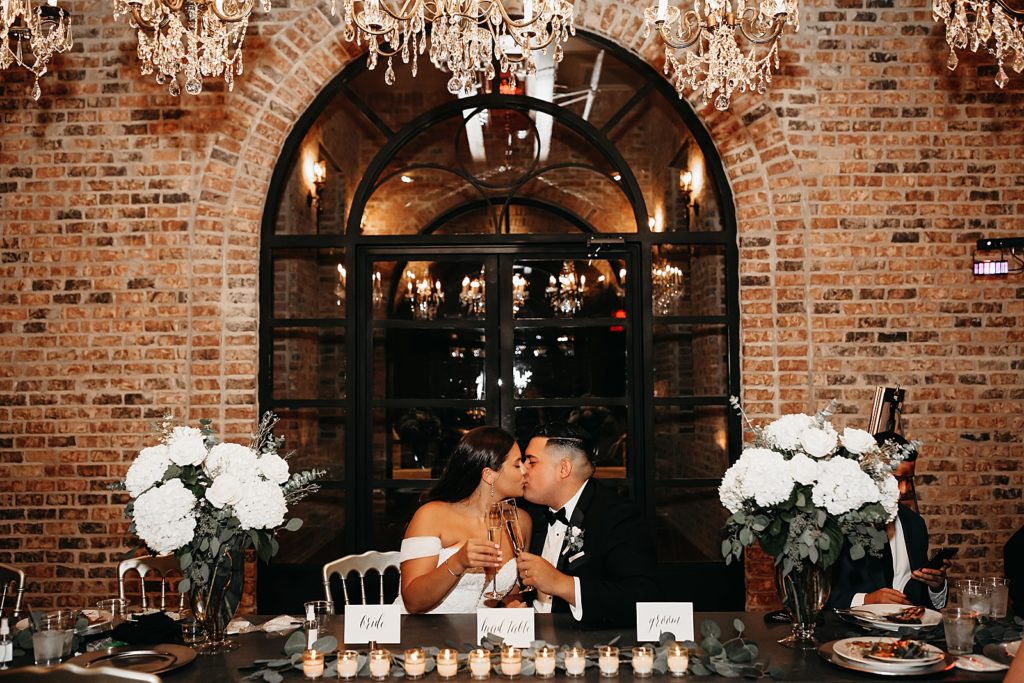 Newlyweds kiss and toast at their elegant Texas reception. 