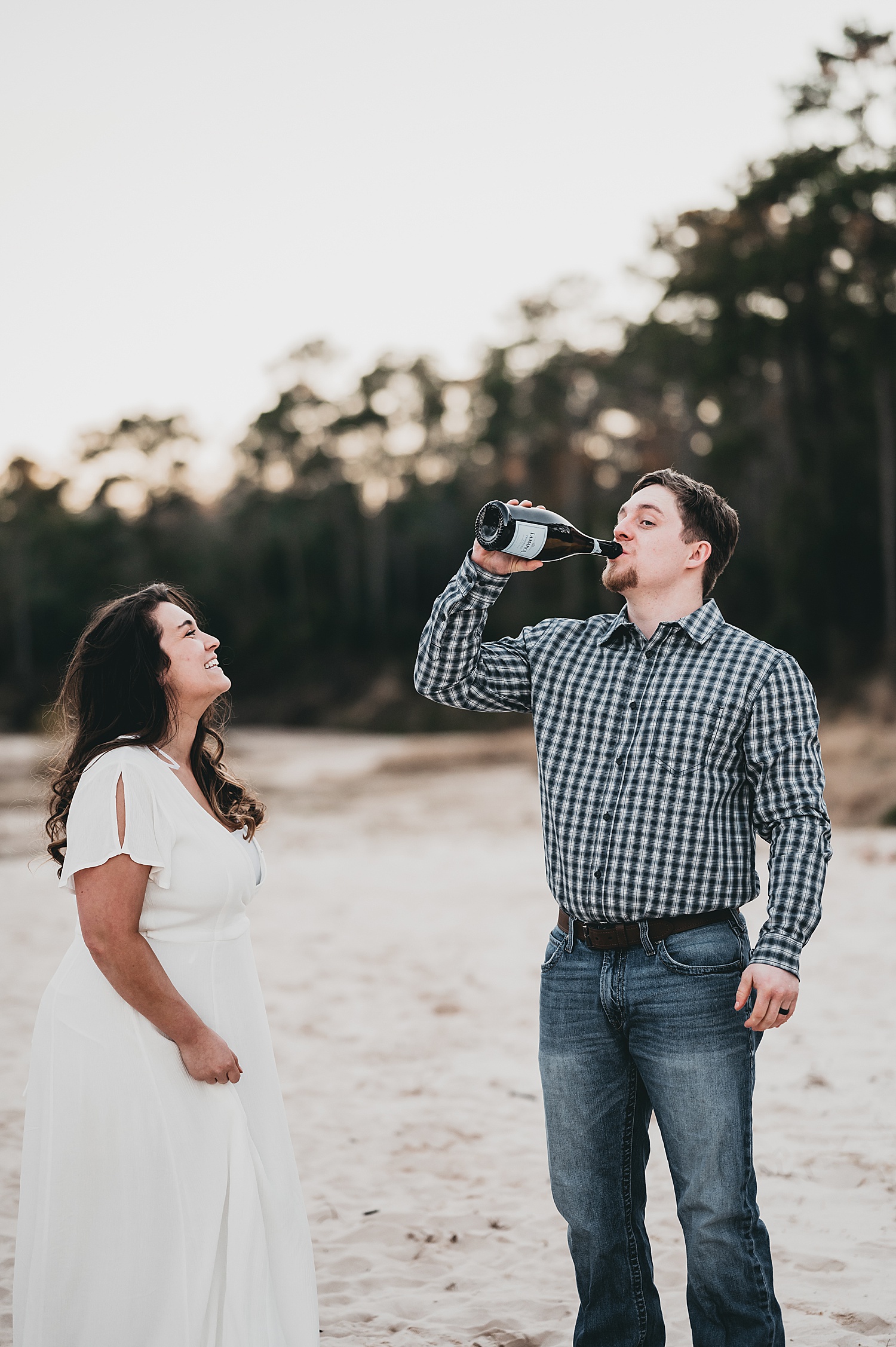man drinking champagne with new fiancé during sunny engagement session