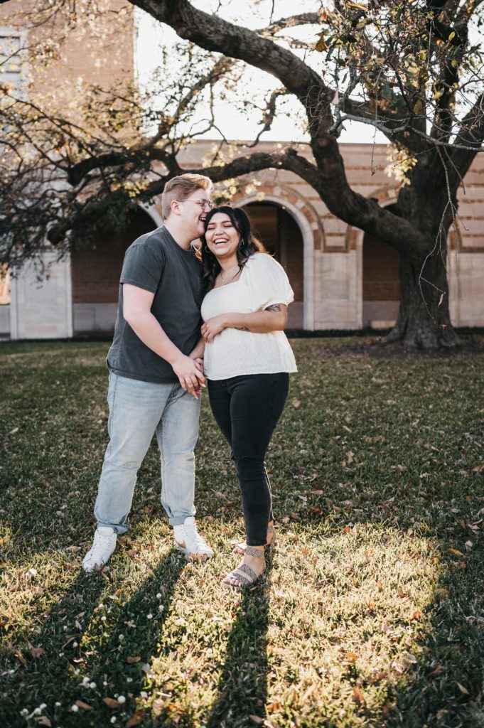 couple laugh while holding hands during their engagement session