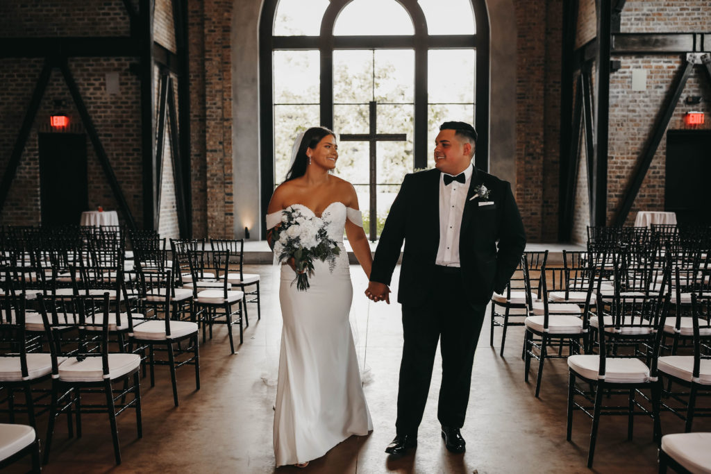 Couple holding hands and smiling at Iron Manor wedding venue in Houston, Texas